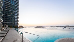 Area piscina con poltrone relax e vista sul mare.