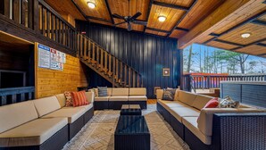 Ein gemütlicher Lounge-Bereich mit Treppe, bequemen Sitzmöglichkeiten und Deckenventilator.