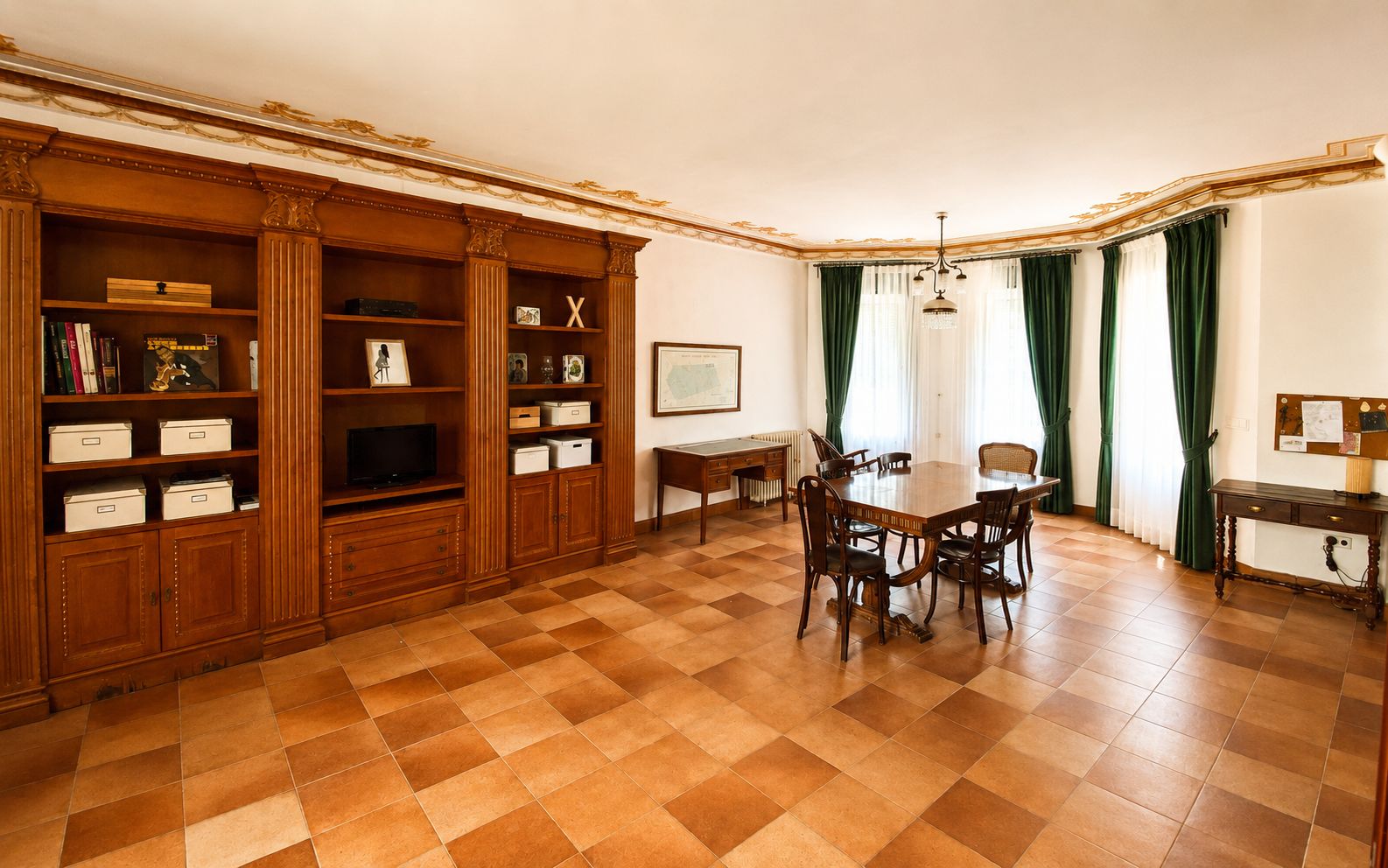 A dining area with a checkered floor, wooden furniture, and a large table with chairs.