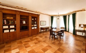 A dining area with a checkered floor, wooden furniture, and a large table with chairs. - Historic Villa with Private Pool & Gardens near Valencia (Alzira)