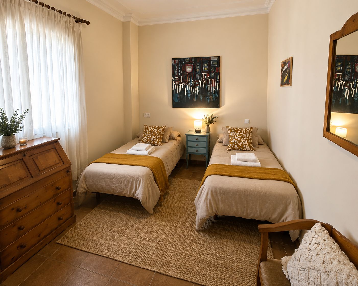Quarto com duas camas, mesa de cabeceira, cômoda e espelho.