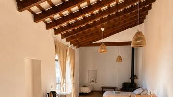 Una habitación con cama, escritorio y zona de comedor.