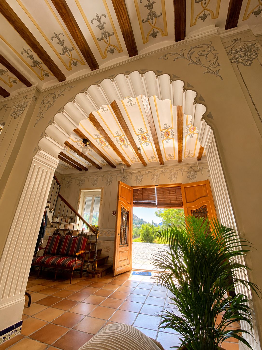Un arco de entrada que da a una escalera con vistas a un jardín.