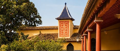 A courtyard with a reflective pool, traditional architecture, and a tiled roof.