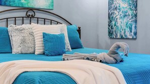 A bed with a blue quilt, fluffy pillows, and a towel. - Pretty Peacock: 2BR/2BA near SDC & Lake Access! (Branson West)