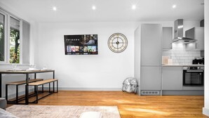 A modern kitchen with grey cabinets, a built-in oven, and a wall-mounted clock. - Uebert Heights| 2Bed| Slp6| Closest to Cannock Town (5min walk)| Free Parking (Cannock)