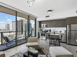 A modern apartment with a balcony, a kitchen, and a city view. - Luxury Studio Suite City Views Downtown Miami (Miami)