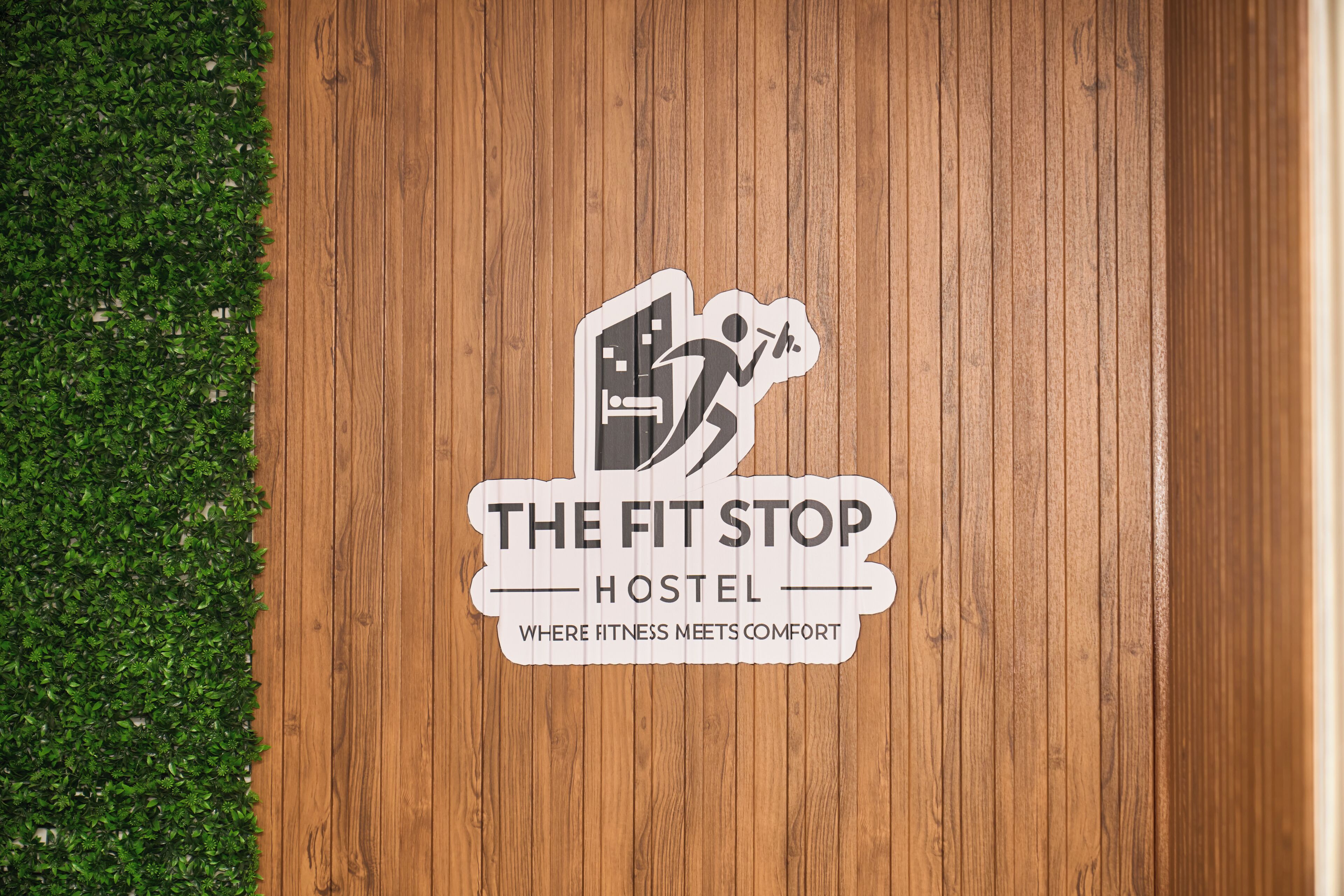 A wooden floor with a logo for "The Fit Stop Hostel" featuring a running figure.