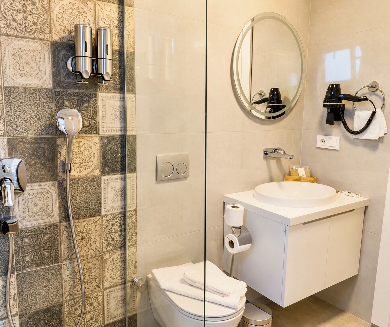 A bathroom with a glass shower enclosure, a toilet, a sink with a mirror, and a towel rack.