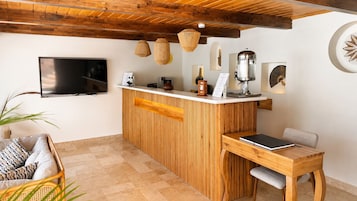 Una cocina moderna con barra de madera, televisor de pantalla plana y comedor con mesa y sillas.