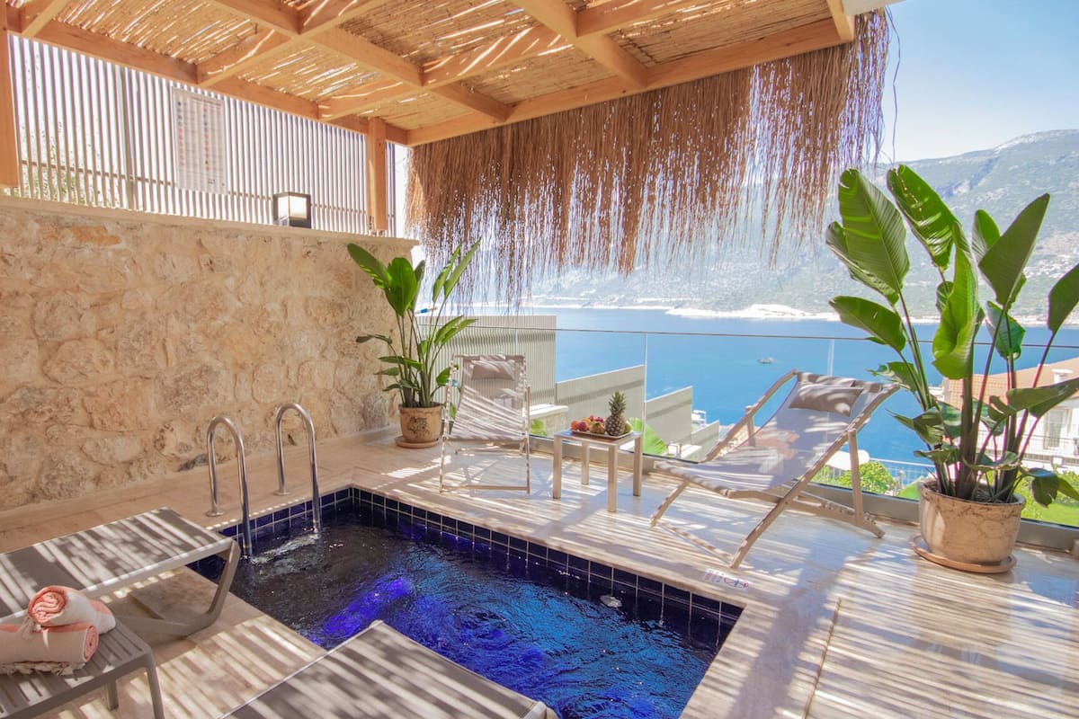 Un área de spa con piscina, sillas de descanso y plantas en macetas.