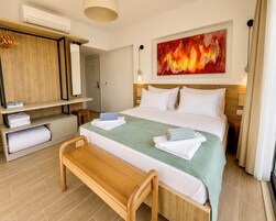 Habitación de hotel con cama, un banco, armario y una pintura.