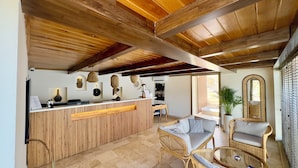 A reception area with a wooden reception desk, wicker furniture, and a large mirror. - Adasya Hotel (Kas)