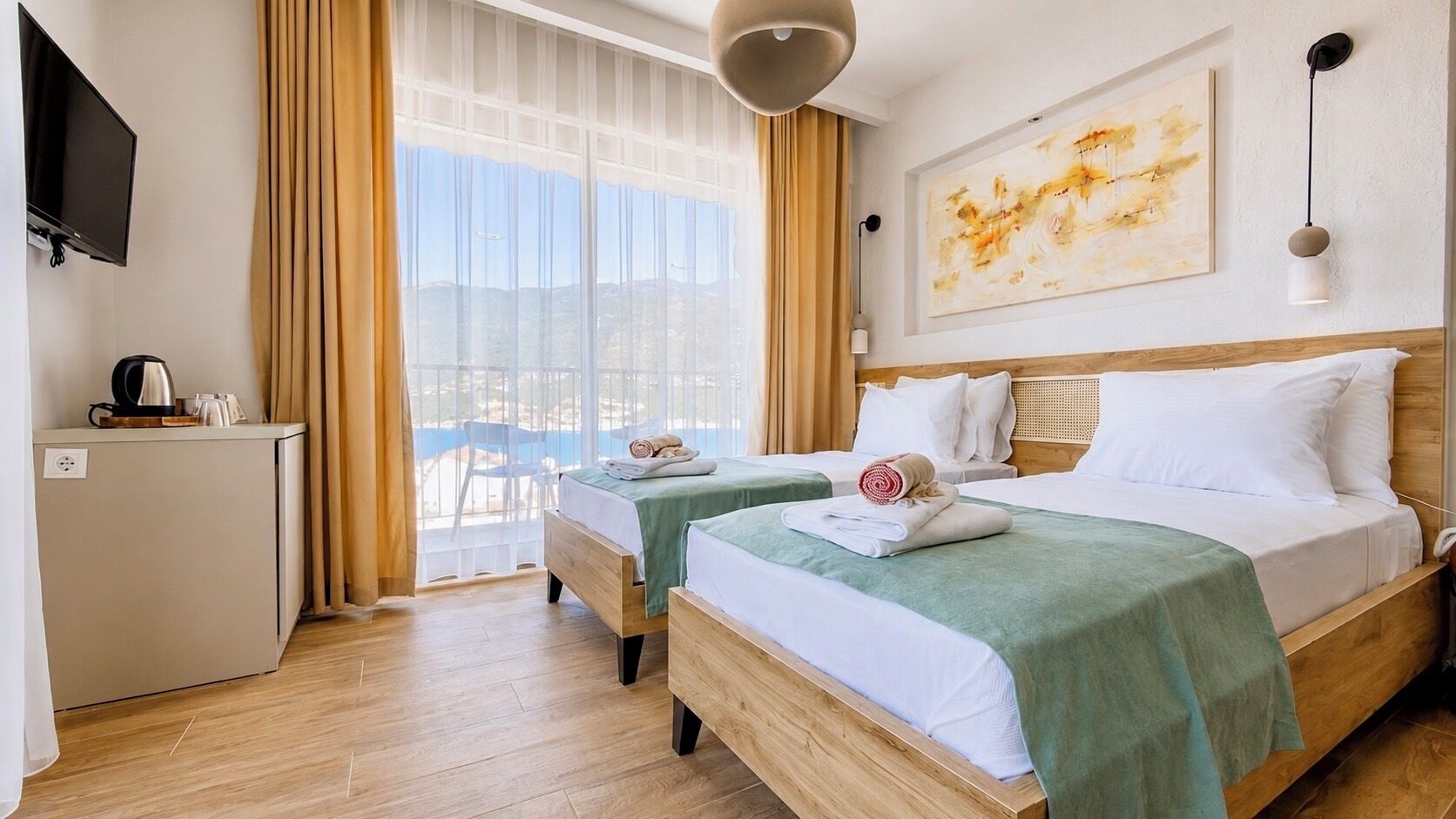 Habitación de hotel con dos camas, un escritorio, un televisor y vistas al exterior.
