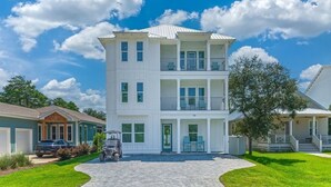 A two-story white building with a balcony, a garage, and a driveway. - Encore: New build! Beach access! (Santa Rosa Beach)