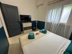 A hotel room with a bed, a TV, a dresser, and a window with curtains. - Koly'Dream Ti Kokoon • Private terrace & shared pool • Saint-François (ST FRANCOIS)