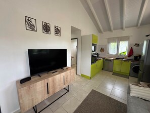 A modern kitchen with a TV, a dining area with a sofa, and a living room with a TV. - Koly'Dream - Ti Kokoon - Villa with Pool in Saint-François (ST FRANCOIS)