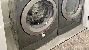 A front-loading LG washer and dryer unit with a control panel, a detergent dispenser, and a safety tag. - Pakallen De-Paris Ensuite Master Bdrm 5 min to UofA, UofA Hospital. Free wifi (Edmonton)