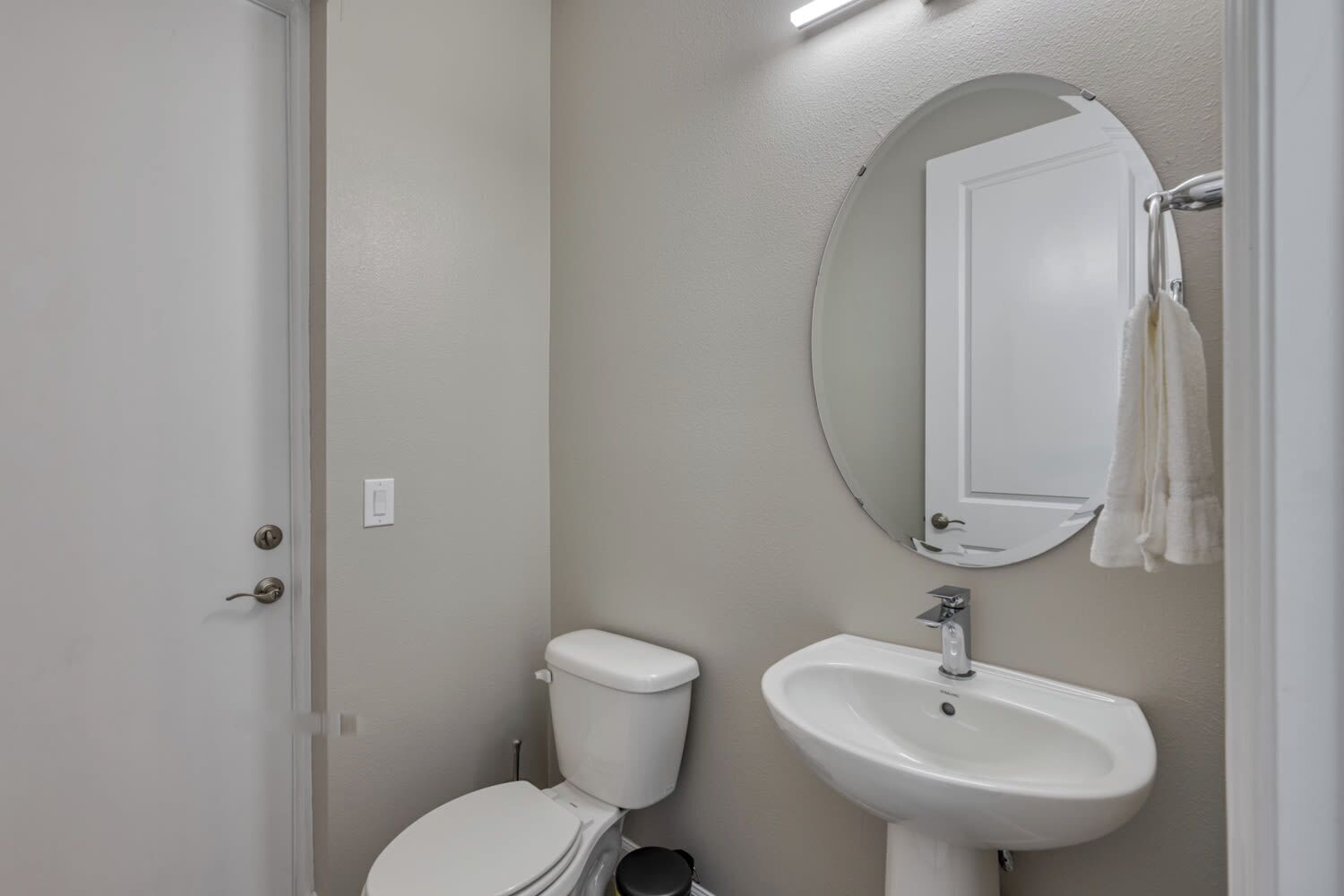 Ein Badezimmer mit Toilette, Waschbecken und Spiegel.