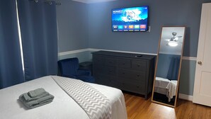 A bedroom with a bed, a dresser, a chair, a TV on the wall, and a mirror. - Family friendly Home, 3BR, Old Town, Nat. Harbor & DC. Nice neighborhood (Alexandria)
