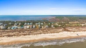 An aerial view of a coastal residential area with houses along the beachfront, a sandy beach, and a view of the ocean. - Blue Palms- 4/3 Gulf View home, WIFI, great views! (Cape San Blas)