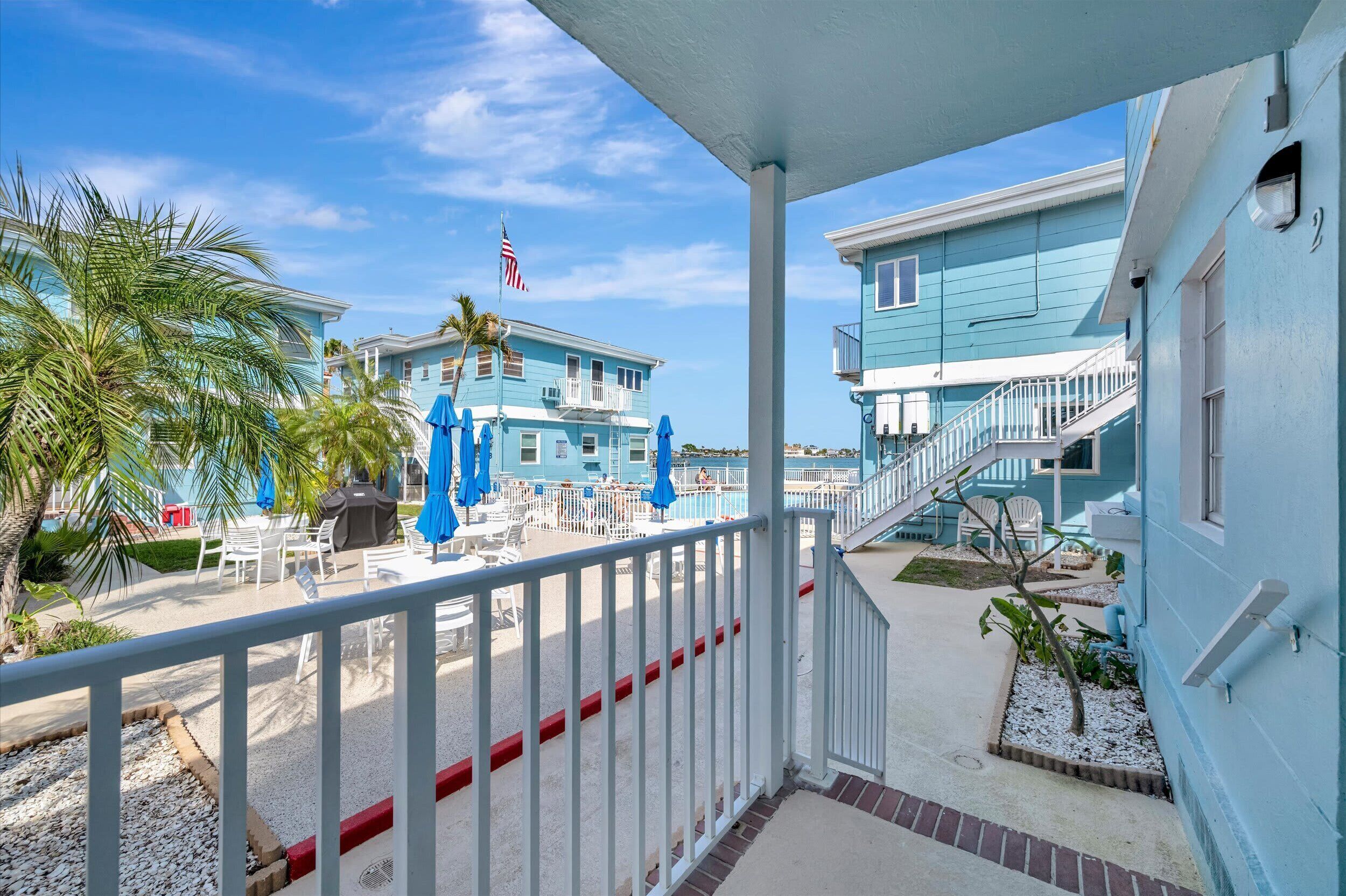 Un hôtel situé en bord de mer, doté d’un balcon, d’un espace extérieur aménagé et d’un drapeau.