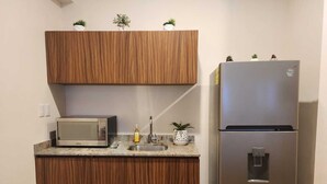 A compact kitchen with a microwave, sink, and stainless steel refrigerator. - Ocean View / Swimming pool / Wifi (Boca del Río)