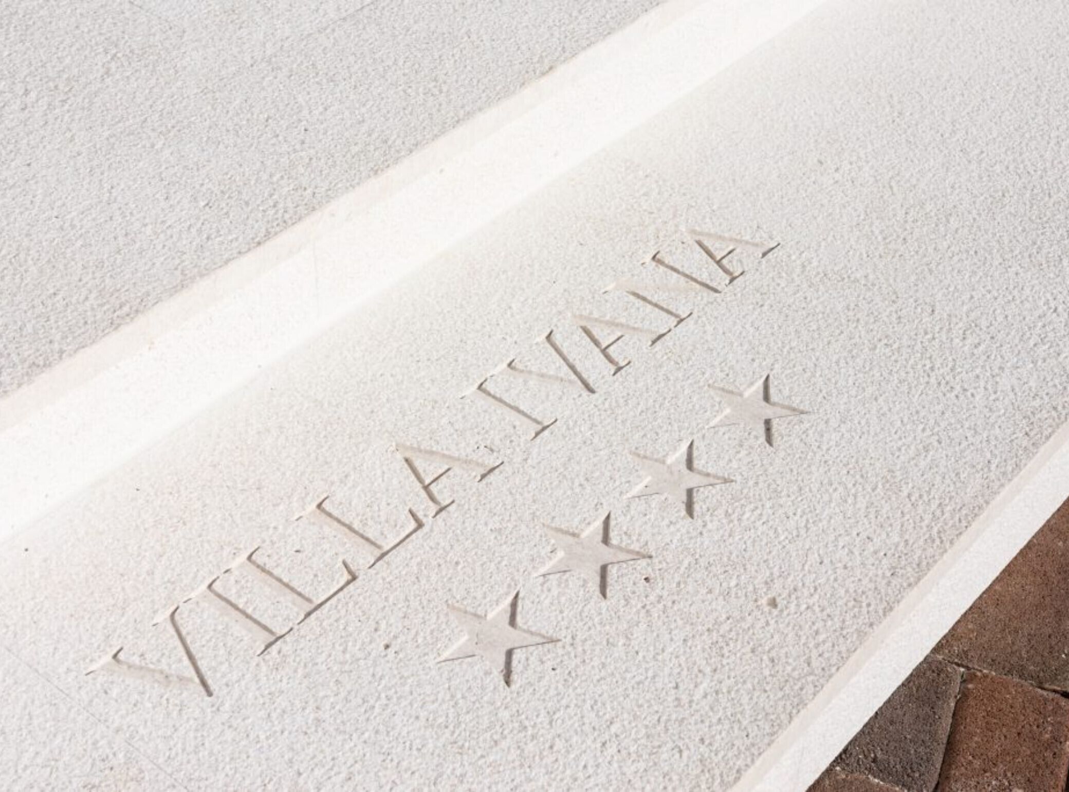 A textured surface with the inscription "VILLA IYAIA" and three stars.