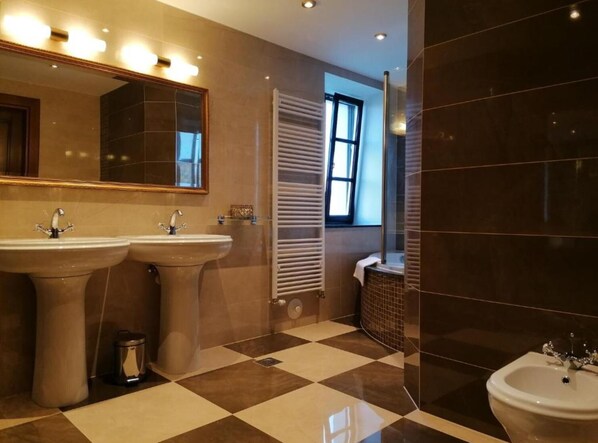 A modern bathroom with two sinks, a large mirror, and a window providing natural light.