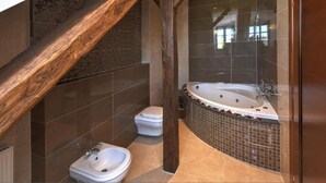 Ein Badezimmer mit freistehender Badewanne, einem Bidet und einer Toilette.