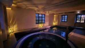 Un espace bien-être comprenant un jacuzzi, une piscine et un coin salon.