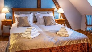 Un dormitorio con una cama grande, dos mesitas de noche y una silla.