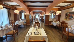 A long dining hall with tables set for service, wooden beams on the ceiling, and a large painting on the wall. - Jurjevec Castle - Standard room 19 (Brezane Lekenicke)