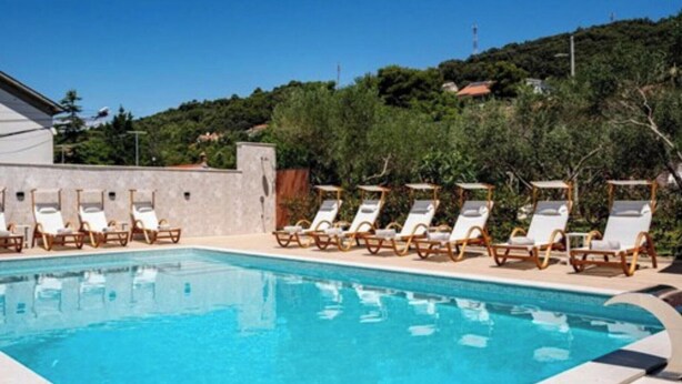 A swimming pool with lounge chairs and a view of a hillside. - Apartments Foric - Two bedroom apartment (1) (Rab)