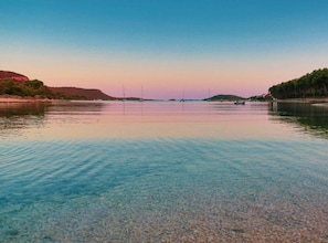 Un lac paisible, aux eaux claires, où l’on peut naviguer, entouré de collines et d’arbres.