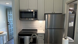 A modern kitchen with stainless steel appliances, a marble countertop, and a built-in microwave. - Beautiful remodeled studio across street to ocean SAWGRASS BEACH VILLAS (Sawgrass)