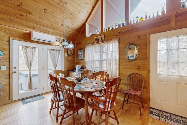 Interior de madera con una mesa de comedor, sillas y una zona de cocina.