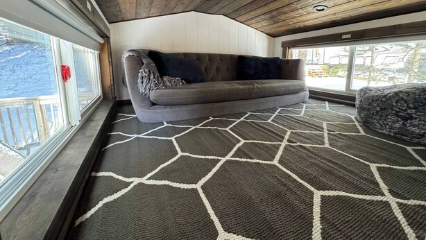 Een gezellig interieur met een bank en een tapijtendecor.