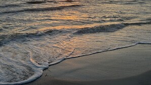Una spiaggia con onde e un tramonto.