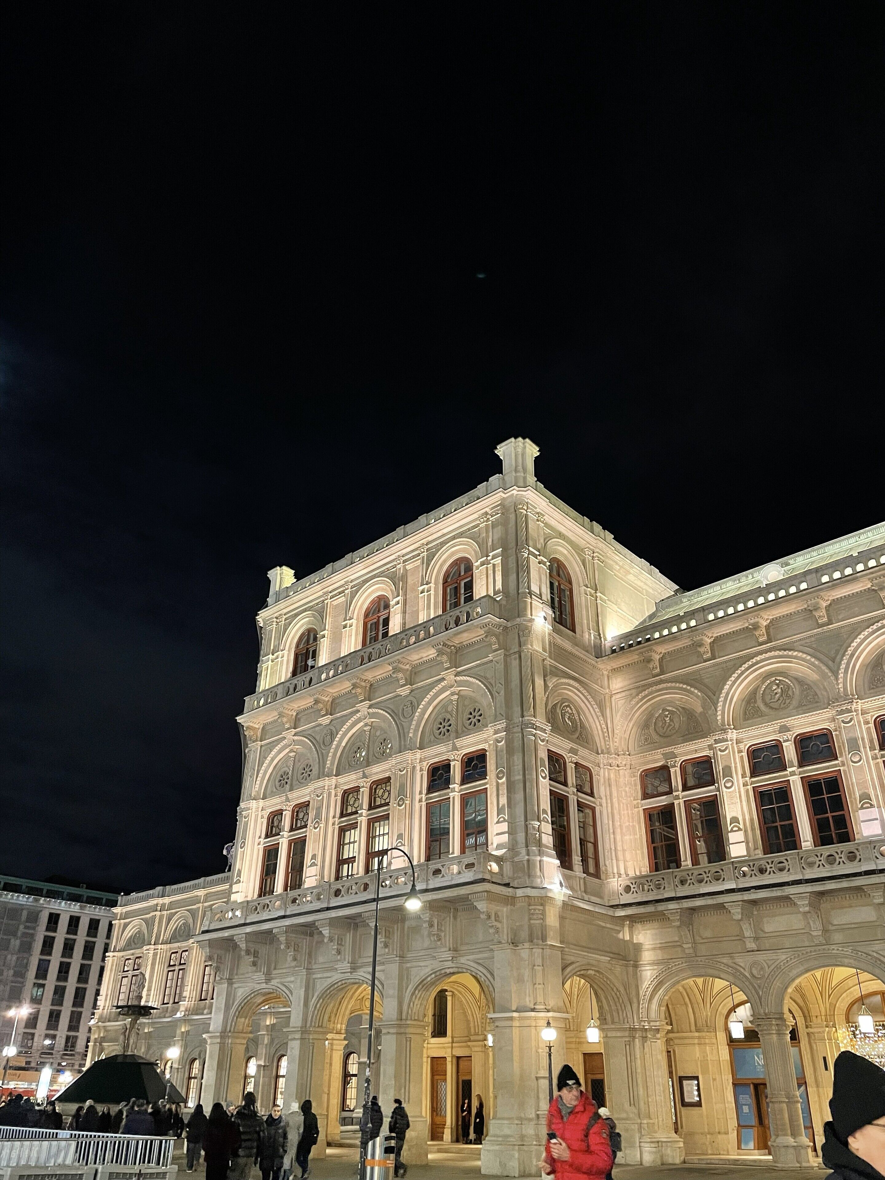 Ein historisches Gebäude mit aufwendiger Architektur, großen Fenstern und einem markanten Eingang.