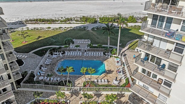 Un hotel con piscina, vista sulla spiaggia e diversi balconi.