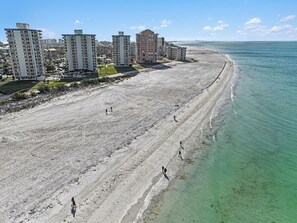 A beach with high-rise buildings in the background. - Sunset Gulf‑Front Condo  Modern Coastal Interior, Steps to Sand (Fort Myers Beach)