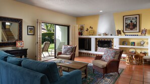 Una sala de estar con un sofá, sillas, una mesa de centro y una chimenea.