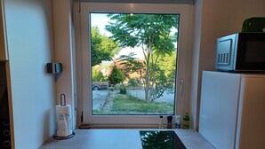 A kitchen with a window, a microwave, and a countertop. - Modern vacation apartment "Am Goldberg" (Neuleiningen)