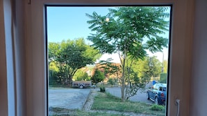 A view through a window with a clear sky, a parked vehicle, and a tree. - Modern vacation apartment "Am Goldberg" (Neuleiningen)