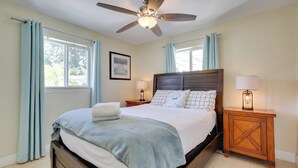 A bedroom with a bed, a ceiling fan, two bedside tables with lamps, and a window with curtains. - 5 Mi to Beaches! Family Home in Fort Lauderdale (Fort Lauderdale)