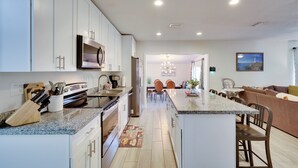 A modern kitchen with white cabinets, a granite countertop, and a central island. - Pool & Patio! Gem 4 Mi to Fort Lauderdale Beach (Fort Lauderdale)