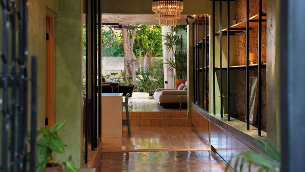 A hallway with a tiled floor, a sofa, a table, and potted plants. - House in Merida near Parque de las Americas. (For families and couples) (Mérida)