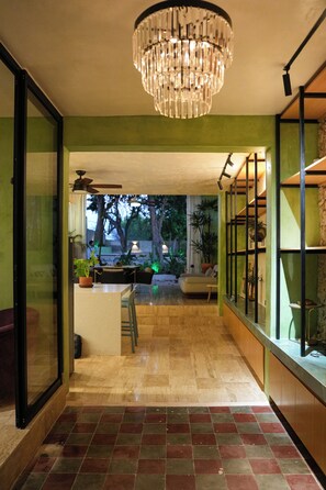 A modern interior with a chandelier, a dining area, and a view of the outdoors. - House in Merida near Parque de las Americas. (For families and couples) (Mérida)