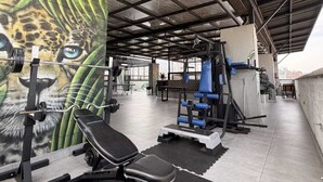 A gym with weightlifting equipment, a bench, and a mural of a leopard's face. - 1 Bedroom Apartment Helena + Jacuzzi Medellín (Medellín)
